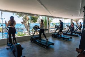a group of people exercising on treadmills in a gym at Lake Side Apart Hotel in Brasília