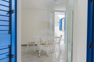 a dining room with a white table and chairs at la casa celeste di Paf in Torre Suda