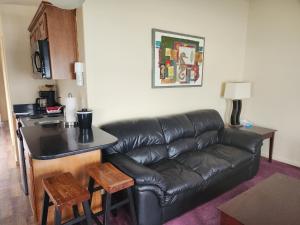 a living room with a leather couch and a table at Seahorse Oceanfront Lodging in Lincoln City