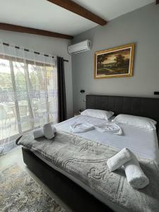 a large bed in a bedroom with a window at Hotel Millenium Tirana in Tirana