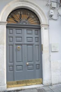 een grote grijze deur in een gebouw bij CASA ALMIKA PRINCIPE AMEDEO in Bari