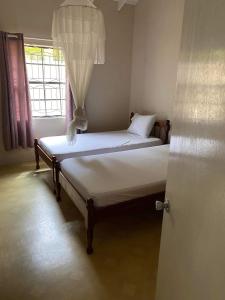 2 camas en una habitación con ventana en The View Villa en Port Elizabeth