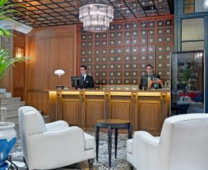 two men sitting at a bar in a lobby at Boutique Hotel H10 Villa de la Reina in Madrid