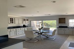a kitchen with white cabinets and a table and chairs at 3 Bd Beverly Hills House in Los Angeles