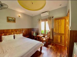 a bedroom with a large white bed and a window at Liên Tho Hotel in Phu Quoc