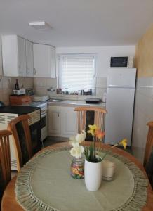 a kitchen with a table with a vase of flowers on it at Vikendica Lep pogled in Rtanj