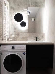 uma cozinha com uma máquina de lavar roupa e um lavatório em Apartament Kraszewskiego em Bialystok
