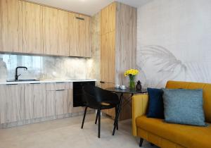 uma cozinha com uma mesa e um sofá amarelo em Apartament Kraszewskiego em Bialystok
