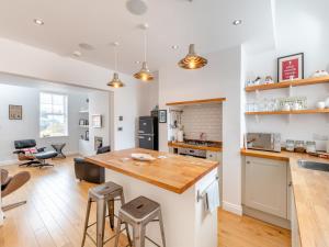 una cucina con bancone e sgabelli in una stanza di Pebble Cottage a Cullercoats