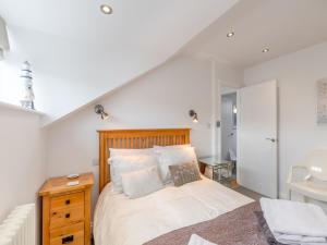 una camera con letto con testiera in legno e lavandino di Pebble Cottage a Cullercoats
