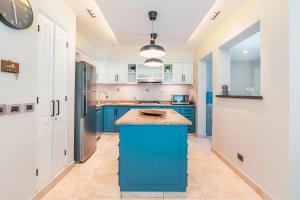 a kitchen with blue cabinets and a blue island at Enjoy this modern pet and family friendly villa B6 in Punta Cana