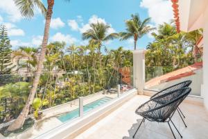 a balcony with a pool and palm trees at Enjoy this modern pet and family friendly villa B6 in Punta Cana