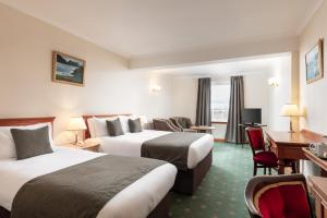 a hotel room with two beds and a desk at North West Castle Hotel in Stranraer