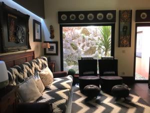 a living room with a couch and chairs and a window at Family Secrets Douro in Riba Douro