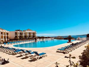 ein großer Pool mit Liegestühlen und ein Resort in der Unterkunft Cannes - Appartement rénové avec vue mer imprenable in Cannes