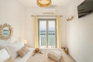 una camera da letto con una grande finestra con vista sull'oceano di Yialos Rooms a Piso Livadi