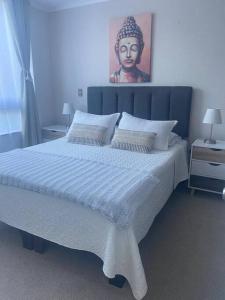 una camera da letto con un grande letto bianco con testiera del letto di Hermoso depto. con estacionamiento a Los Ángeles