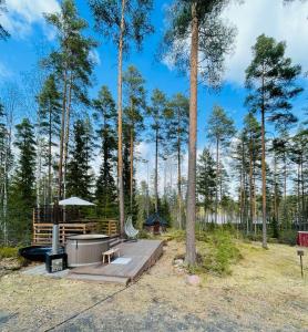 a picnic area with a gazebo and trees at Mökki järven rannalla mäntymetsässä in Forssa