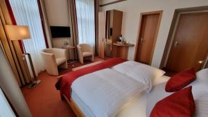 een hotelkamer met 2 bedden en een bureau bij Gasthaus Pension Moselgruss in Dieblich