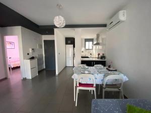 een eetkamer met een tafel en stoelen en een keuken bij Sunny Ground floor bungalow opposite the swimming pool in Orihuela +25 foto's