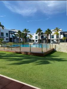 een resort met zwembad en palmbomen bij Sunny Ground floor bungalow opposite the swimming pool in Orihuela