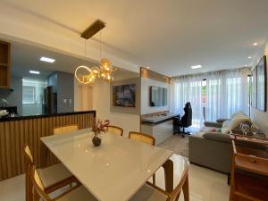 a kitchen and living room with a white table and chairs at Residencial Maranello in Ilhéus