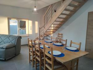 a dining room with a table and chairs and a staircase at Gîte à louer in Labergement-Sainte-Marie