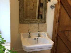 a bathroom with a white sink and a mirror at Cowslip Cottage Ukc1898 in Dogdyke