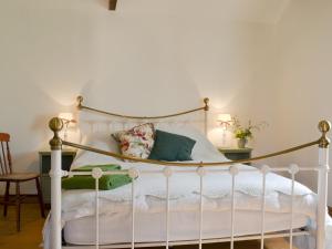 a bedroom with a white bed with white sheets and pillows at Cowslip Cottage Ukc1898 in Dogdyke