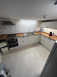a kitchen with white cabinets and a sink at 36 Heritage House in Kington
