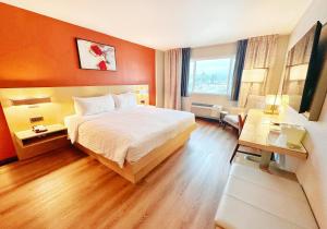 a hotel room with a bed and a living room at Lincoln Hotel Monterey Park Los Angeles in Monterey Park