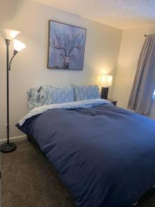 a bedroom with a blue bed with a deer picture on the wall at Newly Remodeled Relaxing Stay near Downtown in Fairbanks
