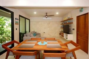 a dining room with a wooden table in a living room at Depto lujoso con jacuzzi privado, Piscina y jungle Gym in Tulum