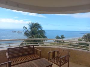 a balcony with two benches and a view of the ocean at Beach View Palace in Porlamar