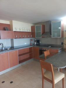 a kitchen with wooden cabinets and a table with chairs at Beach View Palace in Porlamar