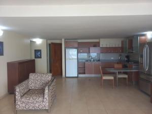 a large kitchen with a table and a refrigerator at Beach View Palace in Porlamar