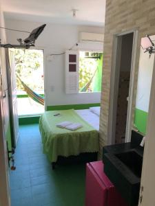 um pequeno quarto com uma cama e um lavatório em Tia Preta Pousada em Morro de São Paulo