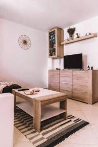 a living room with a table and a tv at Holiday house Zlata in Banjol