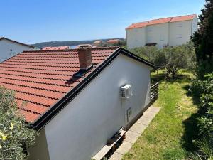 a white building with a red tile roof at Holiday house Zlata in Banjol