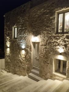 un edificio in pietra con una porta e luci sopra di Oniropagida Nisyros apartment #1 a Nikiá