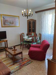 a living room with a red couch and a table at Casa Graziella in Cecina