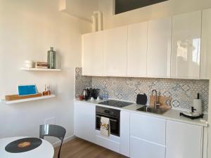 米蘭的住宿－LM Tortona House，厨房配有白色橱柜、水槽和桌子