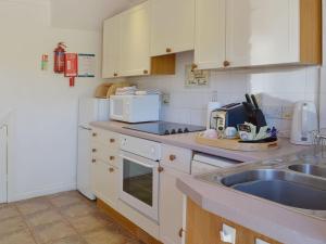 a kitchen with a sink and a microwave at Lambs Gate in Stoke Gabriel