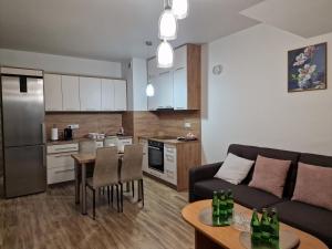 een woonkamer en een keuken met een bank en een tafel bij Apartament Elżbieta in Busko-Zdrój