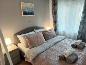 een slaapkamer met een bed met handdoeken erop bij Ozzy Cozy in Zagreb