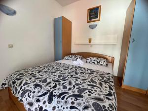 a bedroom with a bed with a black and white comforter at Apartments Jurisic in Baška Voda