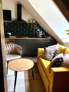 a living room with a yellow couch and a table at Zamkowa 4 in Lubniewice