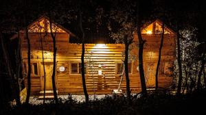 uma cabana de madeira à noite com luzes acesas em Colibri - Cabañas Puerto del Zopilote em Pinal de Amoles