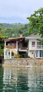 a house on the shore of a body of water at Chue&larry's Beachside Homestay in Libagon
