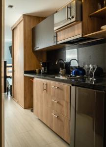 a kitchen with stainless steel appliances and wooden cabinets at Apartamentos Weeki en Chapinero in Bogotá